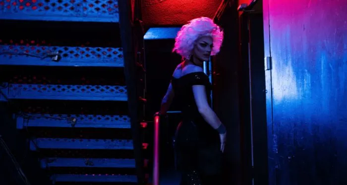 a white drag queen in dark and mysterious lighting